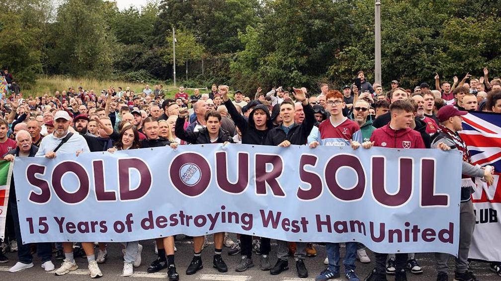 West Ham fans carry a banner reading 'sold our soul - 15 years of destroying West Ham United'