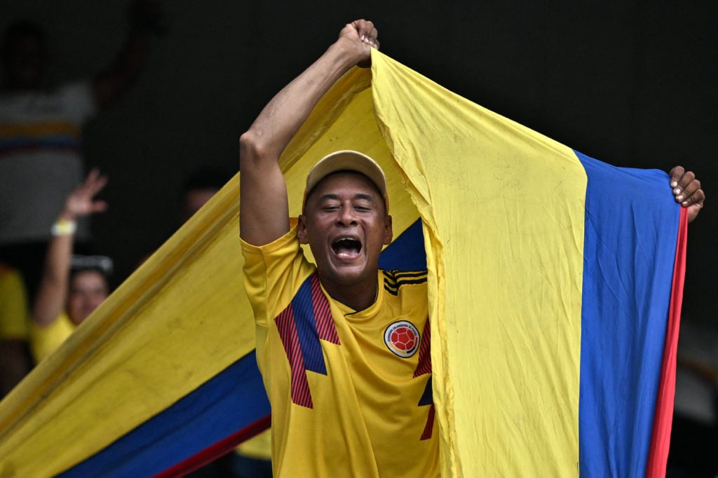 Colombia fans poses with giant flag at football stadium